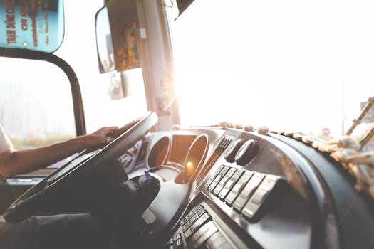pexels photo 977213 977213 A bus driver navigating the city streets during a sunny day, focusing on the road.